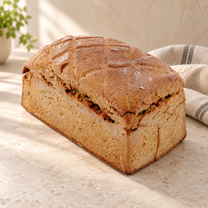 Roggenbrot 600 g von Jungermann Gourmet mit brauner Kruste und Einschnitten auf einer hellen Natursteinfläche.