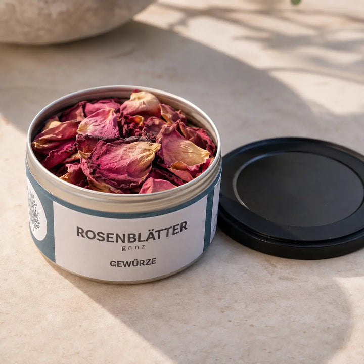Geöffnete Originaldose mit großen ganzen getrockneten Rosenblättern und Deckel daneben