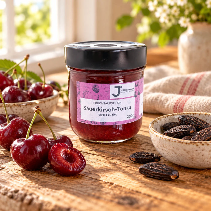 Sauerkirsch-Tonkabohnen Fruchtaufstrich im Originalglas auf rustikalem Holz mit Sauerkirschen und Tonkabohnen als Zutaten
