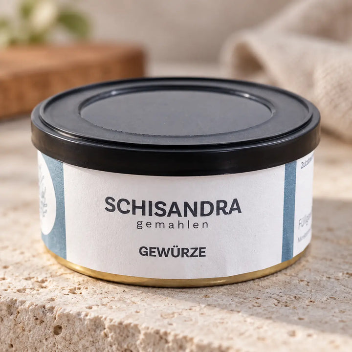 Nahaufnahme der Schisandra-Gewürzdose mit schwarzem Deckel, hellblau-weißem Etikett und goldfarbenem Bodenrand.