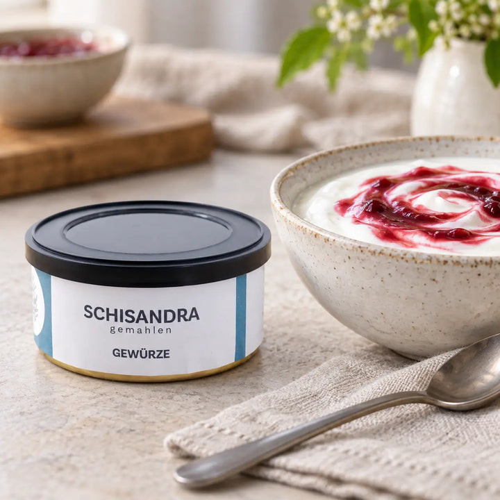 Schisandra gemahlen in der Originaldose neben Joghurt mit roter Fruchtsauce als Serviervorschlag.