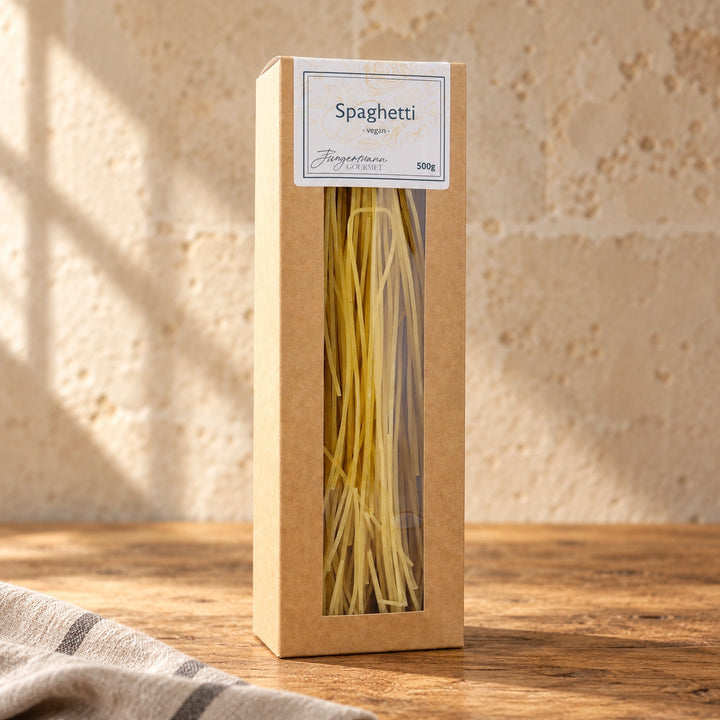 Spaghetti ohne Ei in der originalen 500-g-Kartonverpackung auf einer warmen Küchenarbeitsplatte.