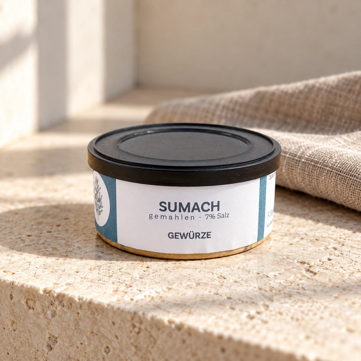 Originaldose Sumach gemahlen mit der Aufschrift 7 % Salz auf einer hellen Natursteinfläche.