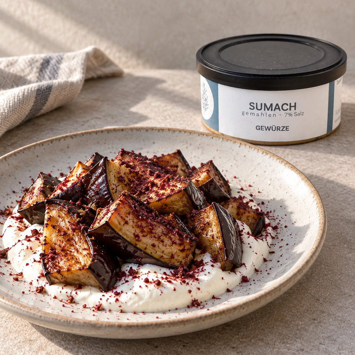 Geröstete Auberginen auf Joghurt mit Sumach neben der Originaldose als Serviervorschlag.