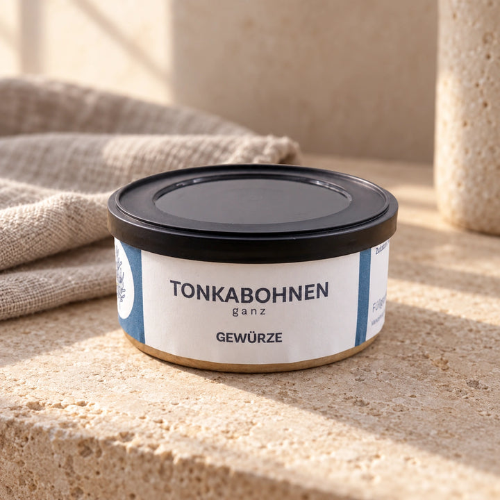 Tonkabohnen in der originalen Gewürzdose auf warmer Natursteinfläche.