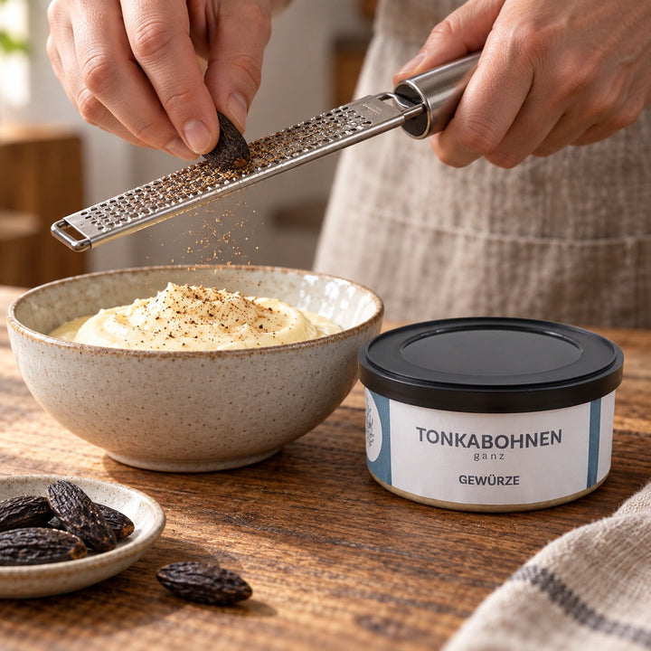 Serviervorschlag: Eine Tonkabohne wird sparsam über eine Creme gerieben; die Originaldose steht daneben.