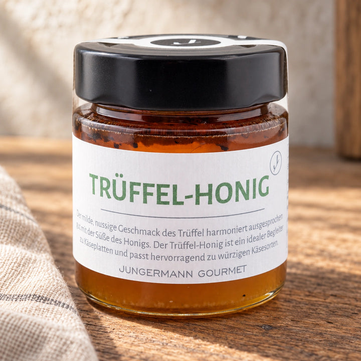 Trüffelhonig im Originalglas auf einer warmen Holzfläche.