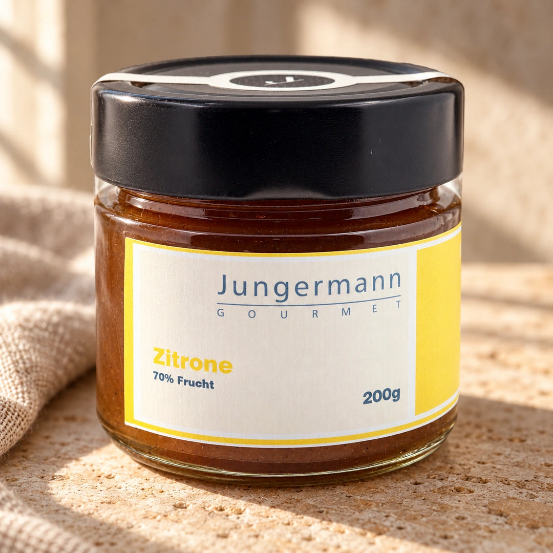 Zitronen-Aufstrich im Originalglas auf warmer Natursteinfläche neben Leinen.