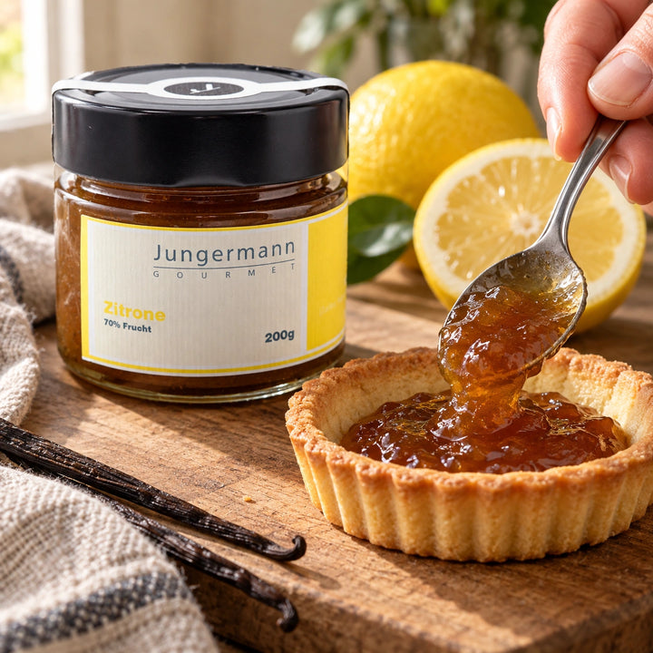 Serviervorschlag: Eine Hand füllt ein Tartelette mit Zitronen-Aufstrich; das Originalglas steht daneben.